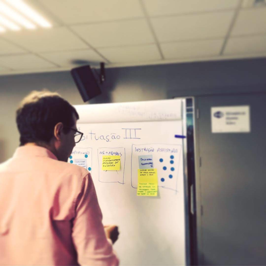 Auditor sketching a low-fidelity prototype on a whiteboard during a workshop